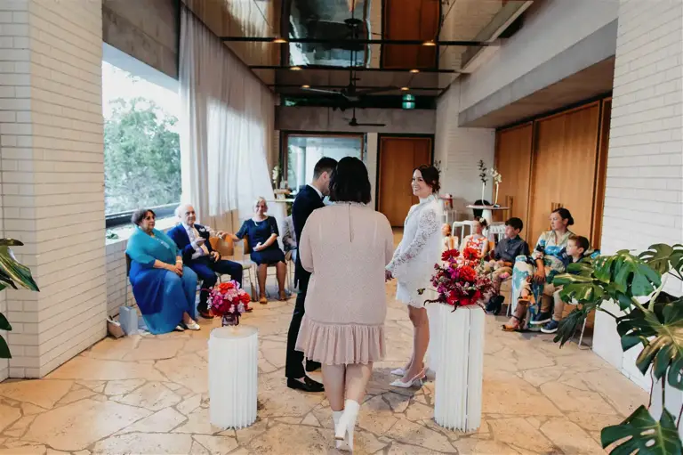 Briony from Lady Love conducts the heartfelt ceremony as Christian and Amy exchange vows, surrounded by their closest family who traveled from around the world