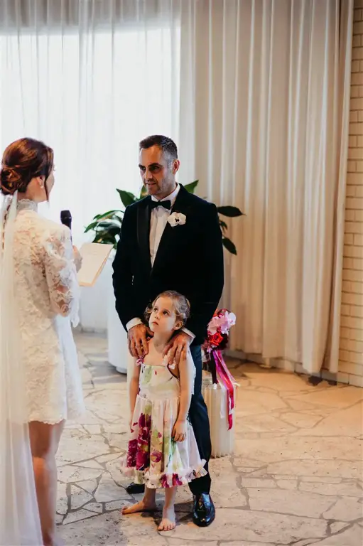 The couple share their first kiss as married partners, with The Calile's distinctive architectural elements framing the intimate moment