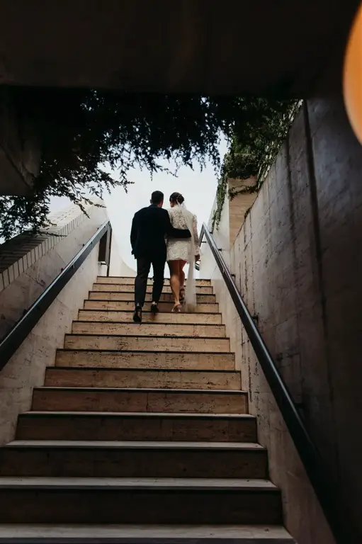 Candid laughter between the newlyweds as they walk along The Calile's open-air corridors lined with tropical plants